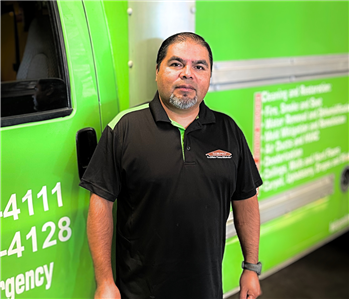 male employee in front of green box truck