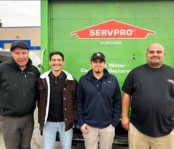 4 male employees in front of company truck