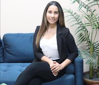 female employee with brown hair sitting on couch for professional headshot