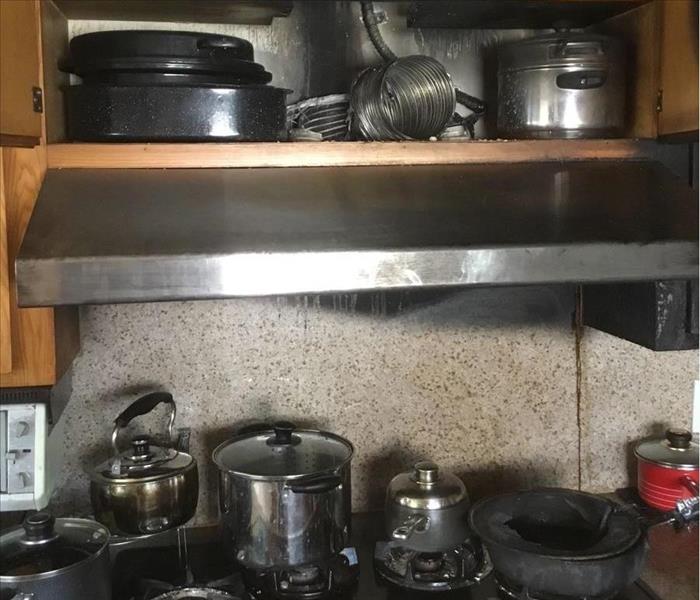 Kitchen stove fire with soot surrounding cabinets